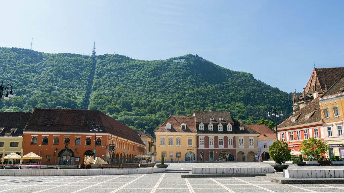 Council Square in Brașov, Romania, with the Brașov sign on Tâmpa mountain behind the old town