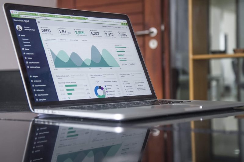 A laptop displaying a web analytics dashboard with traffic charts and usage statistics